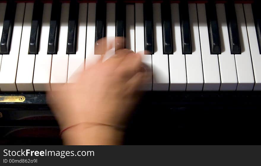 Close-up of a hand playing a chord on a piano keyboard. Close-up of a hand playing a chord on a piano keyboard