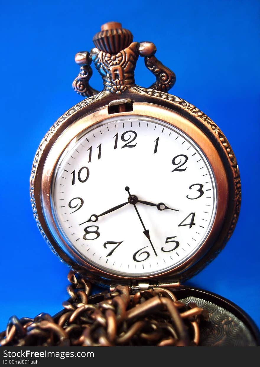 Close-up of old golden clock on blue background