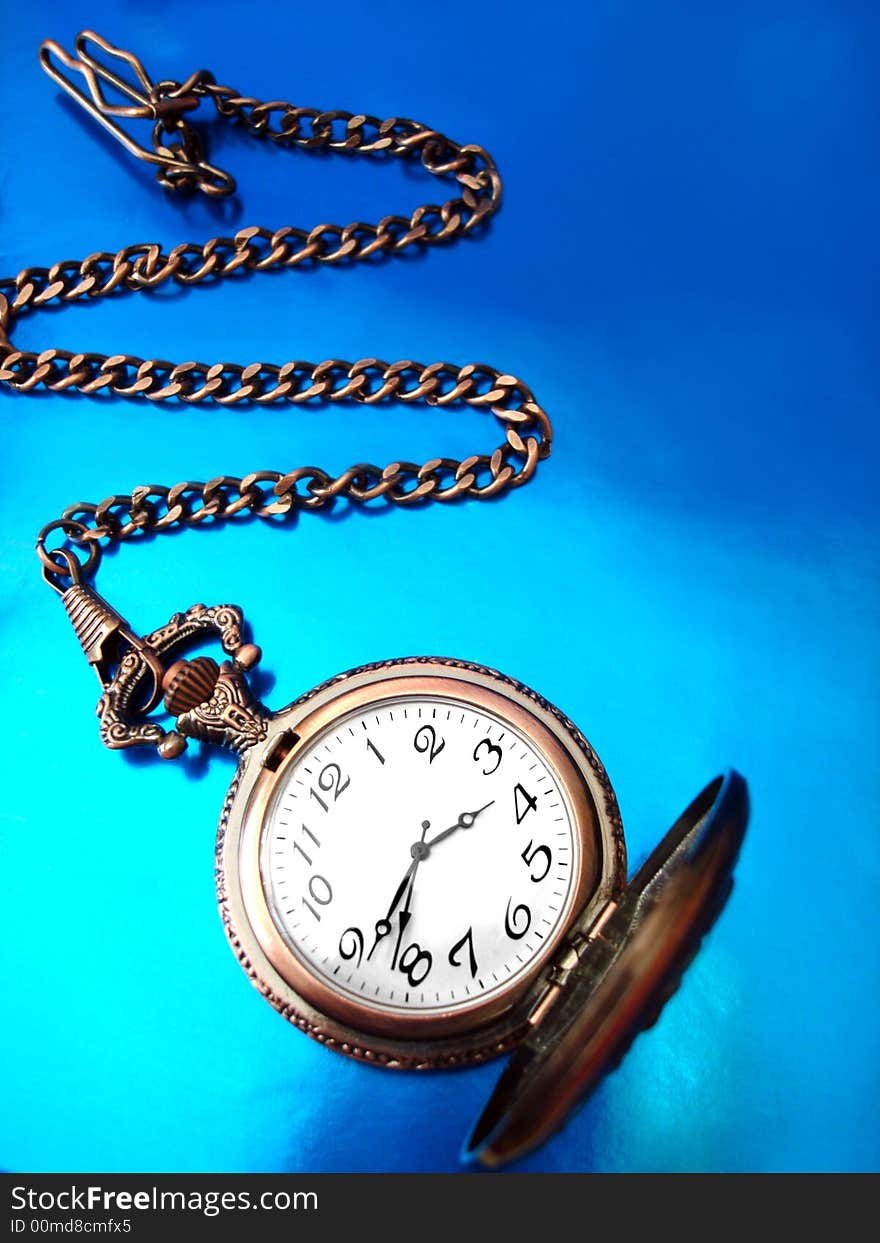 Close-up of old golden clock on blue background