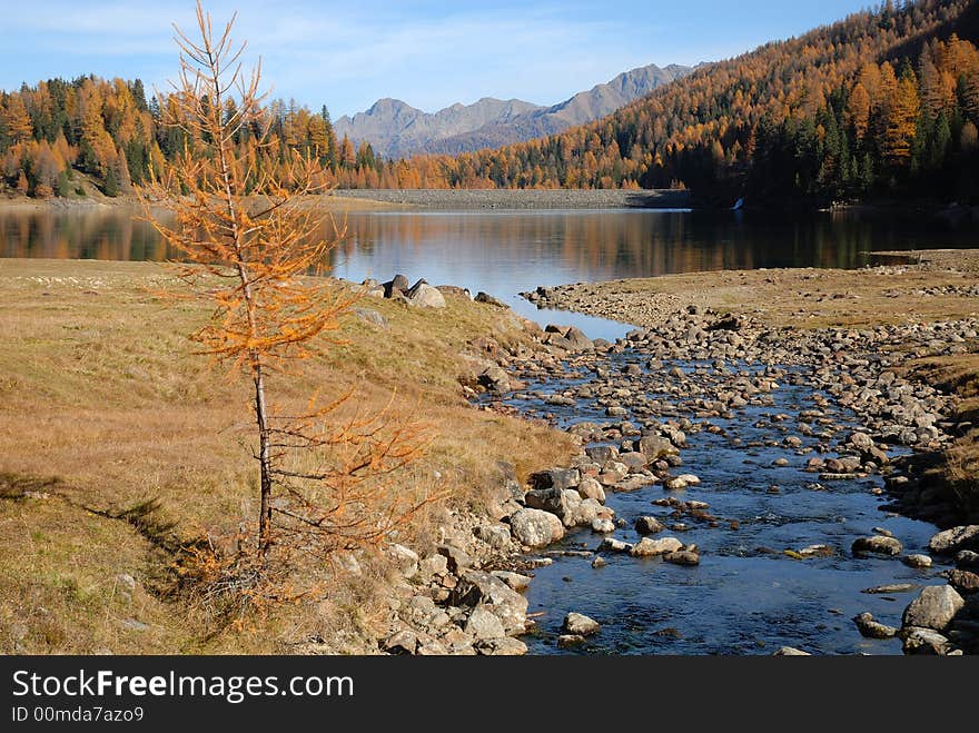 Landscape with a limpid stream and a lake. Mountain in autumn with warm colors. Landscape with a limpid stream and a lake. Mountain in autumn with warm colors.