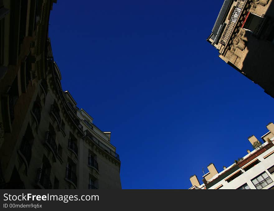 Paris corner of streets as looking up and seeing how the totally blue sky is given a form by the tops of the buildings. Paris corner of streets as looking up and seeing how the totally blue sky is given a form by the tops of the buildings