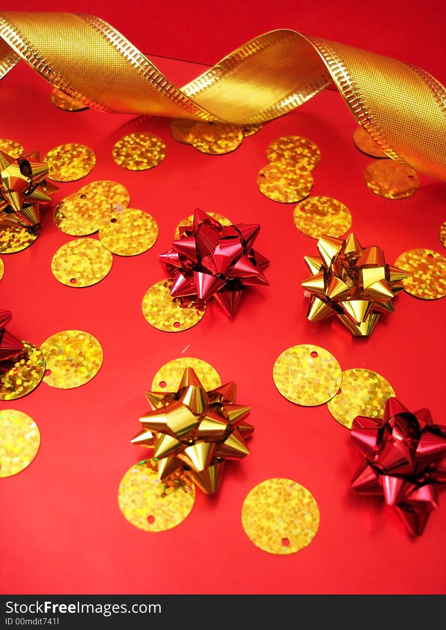 Golden celebratory ribbon and bows on red background