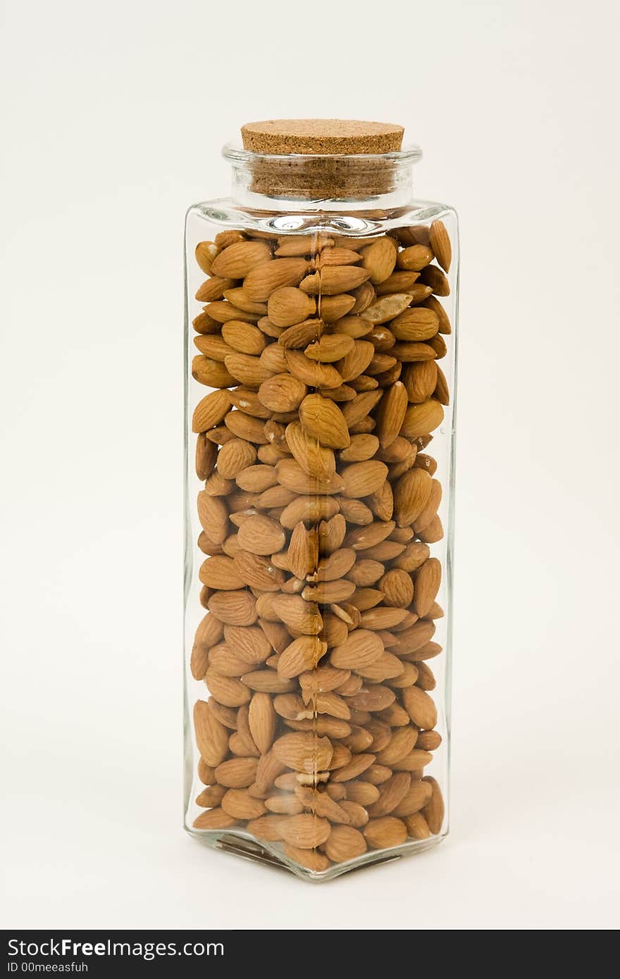 A tall glass jar, full of almonds, one of the healthiest snacks. A tall glass jar, full of almonds, one of the healthiest snacks.