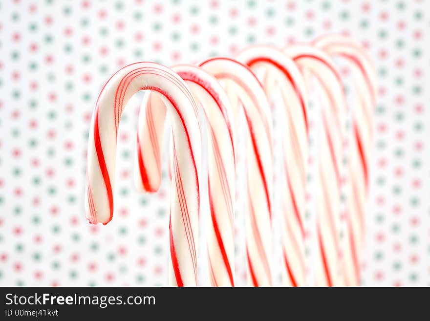 Row of Candy Canes on Red and Green Dotted Background. Row of Candy Canes on Red and Green Dotted Background