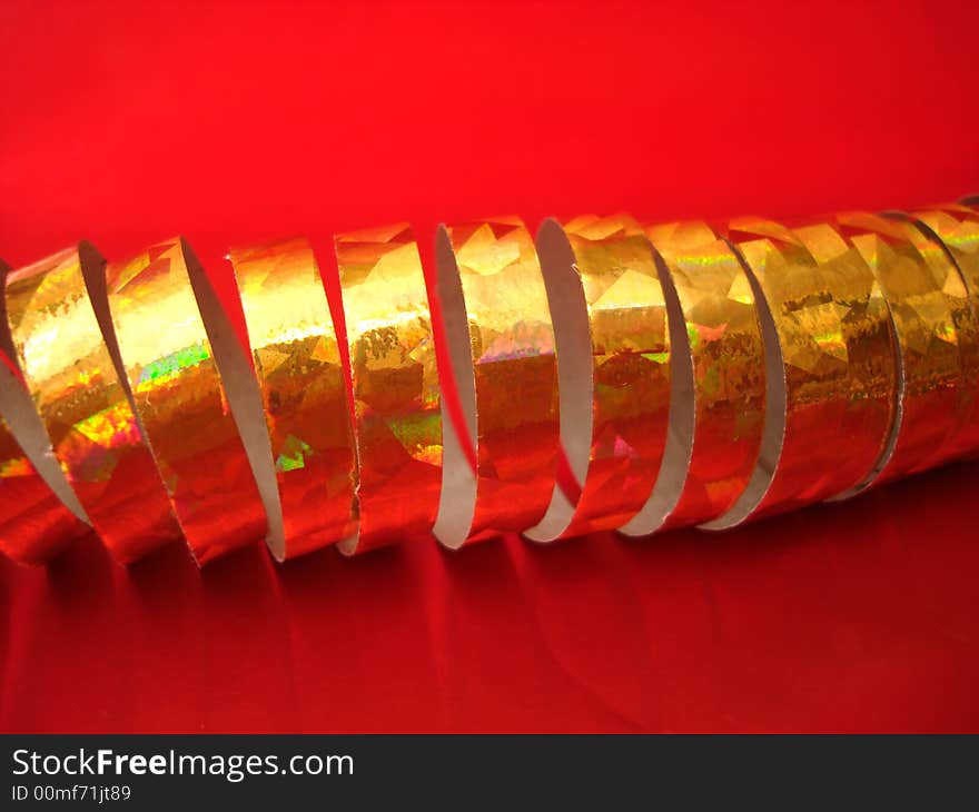 Golden celebratory ribbon on red background