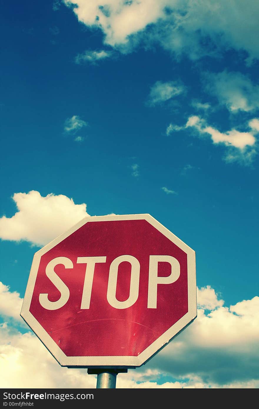 Stop sign and the clouded sky