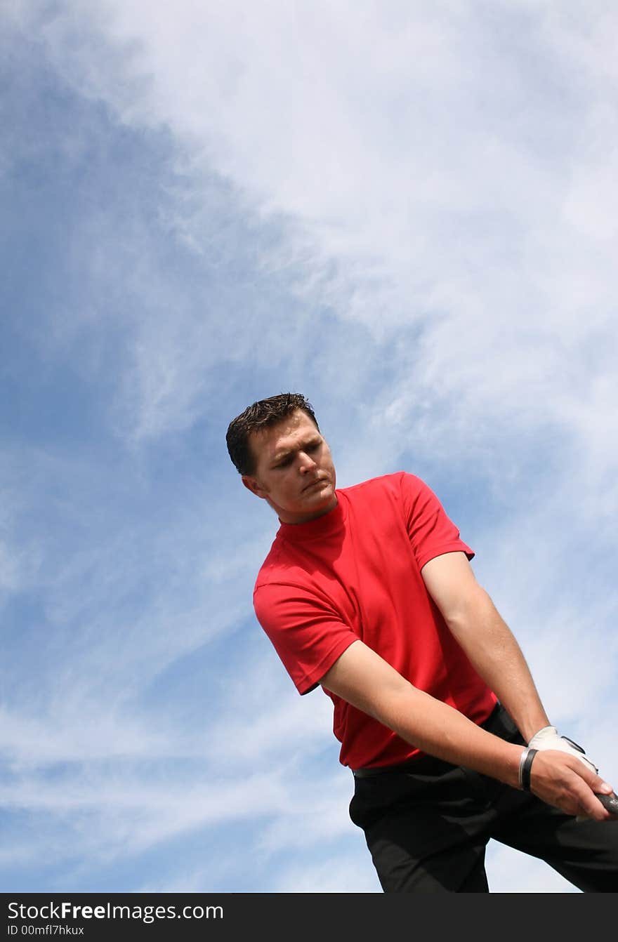 Young golfer at an angle preparing for a shot. Young golfer at an angle preparing for a shot