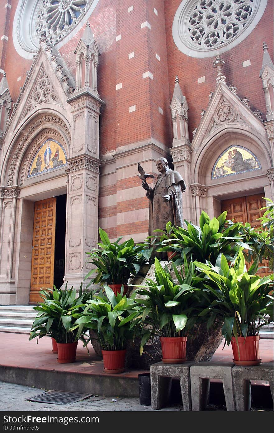 Catholic church with a monument and exotic plants. Catholic church with a monument and exotic plants