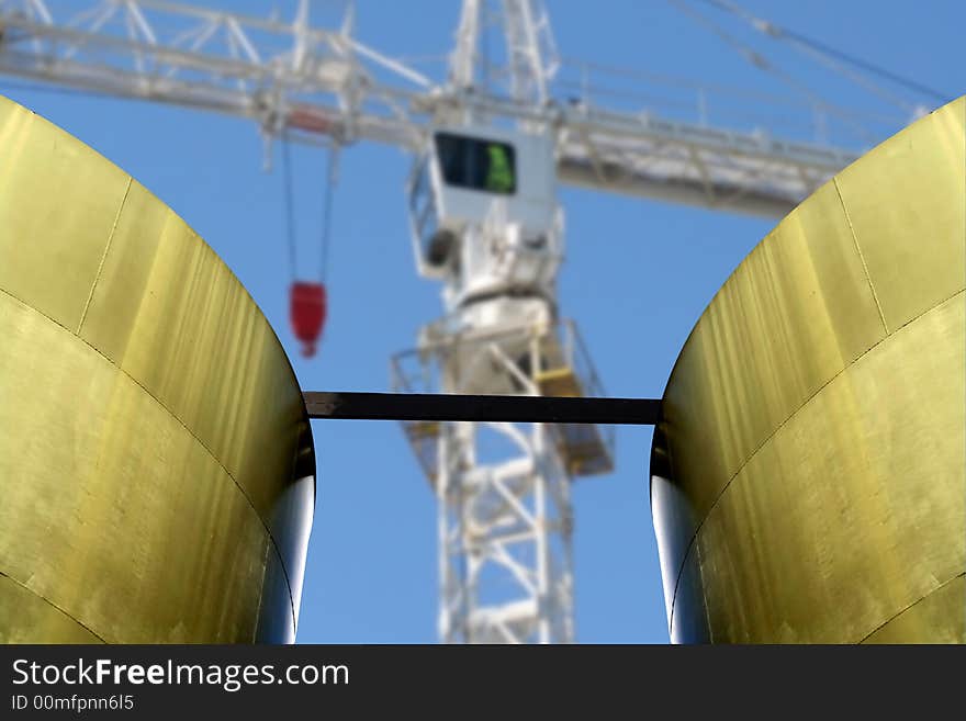 Industrial scene with old storage tank and blurred crane