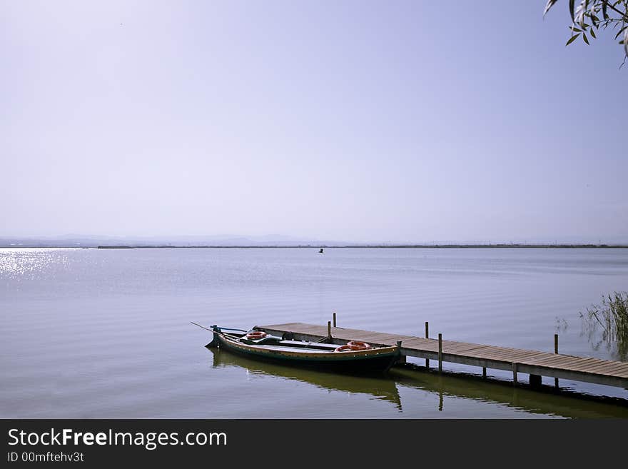 A boat tied in a footbridge, taken in the Albufera, Valencia. A boat tied in a footbridge, taken in the Albufera, Valencia.