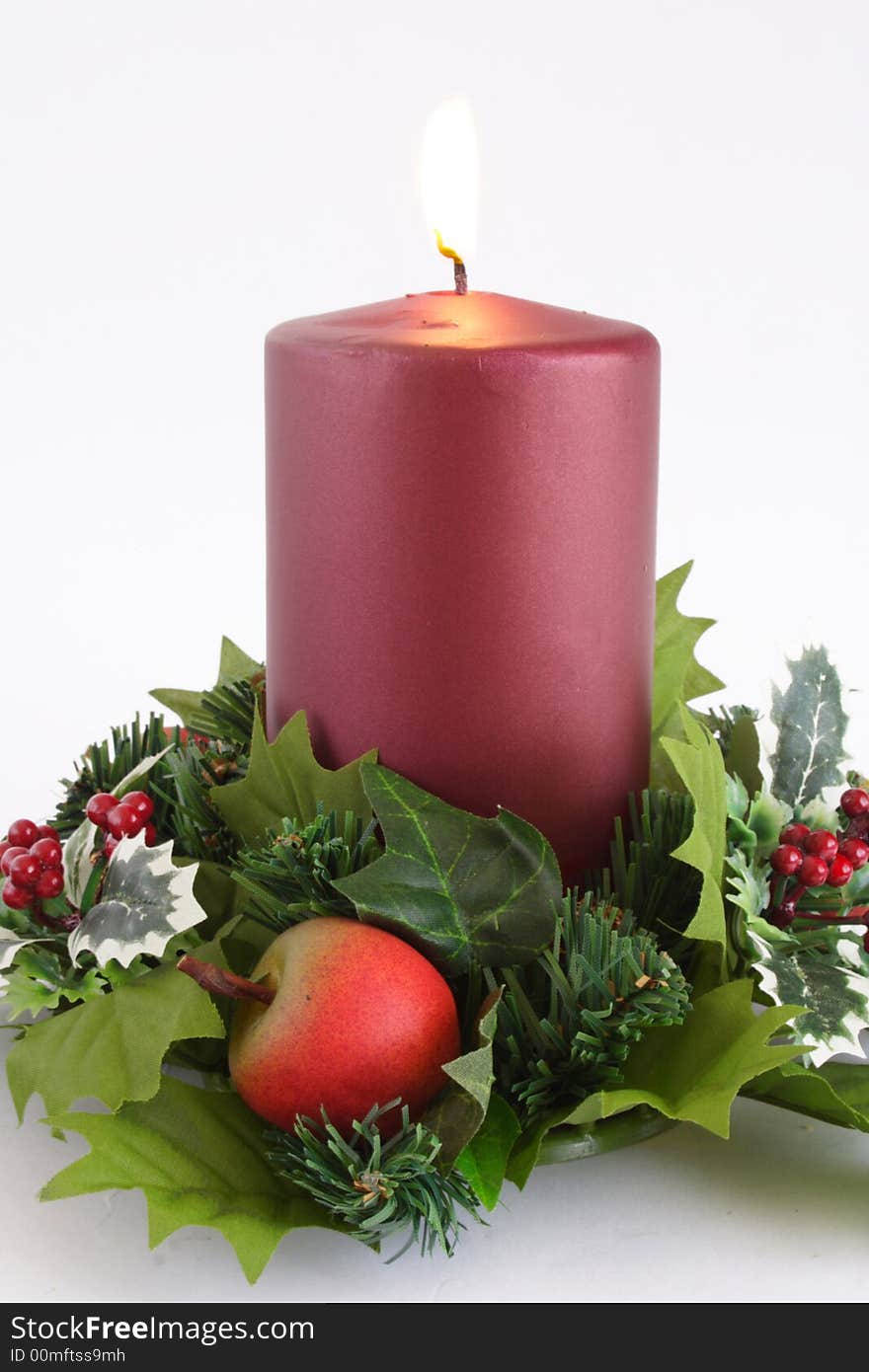 Lit red candle with Christmass decoration