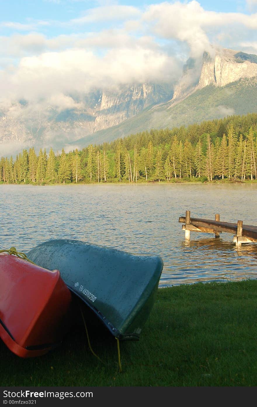 Canoes beside a lake with mountains in the background. Canoes beside a lake with mountains in the background