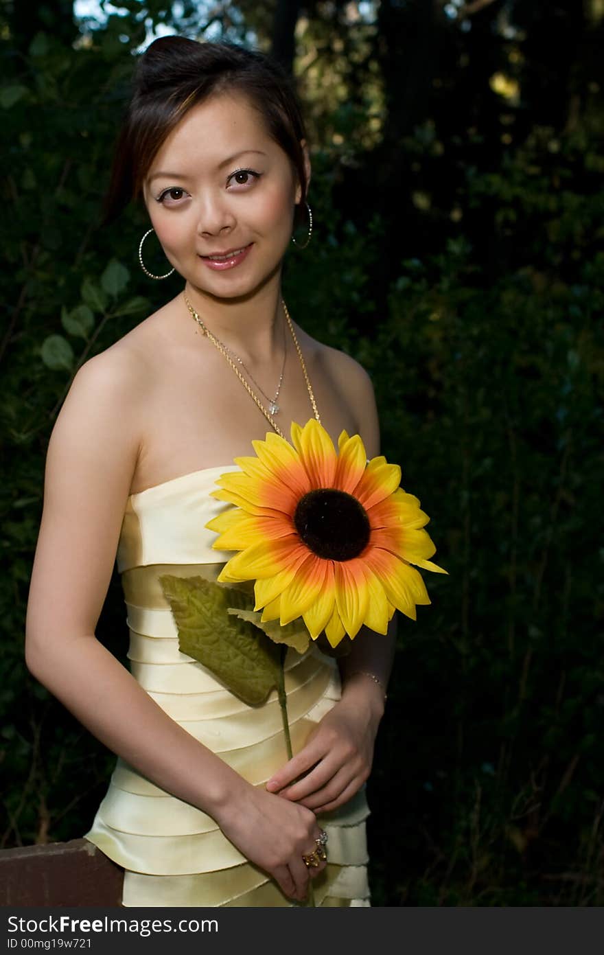 A beautiful girl trying to tell us a sunflower tale in woods