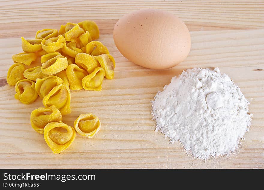 Italian tortellini made in Bologna upon a wood layer with egg and flour