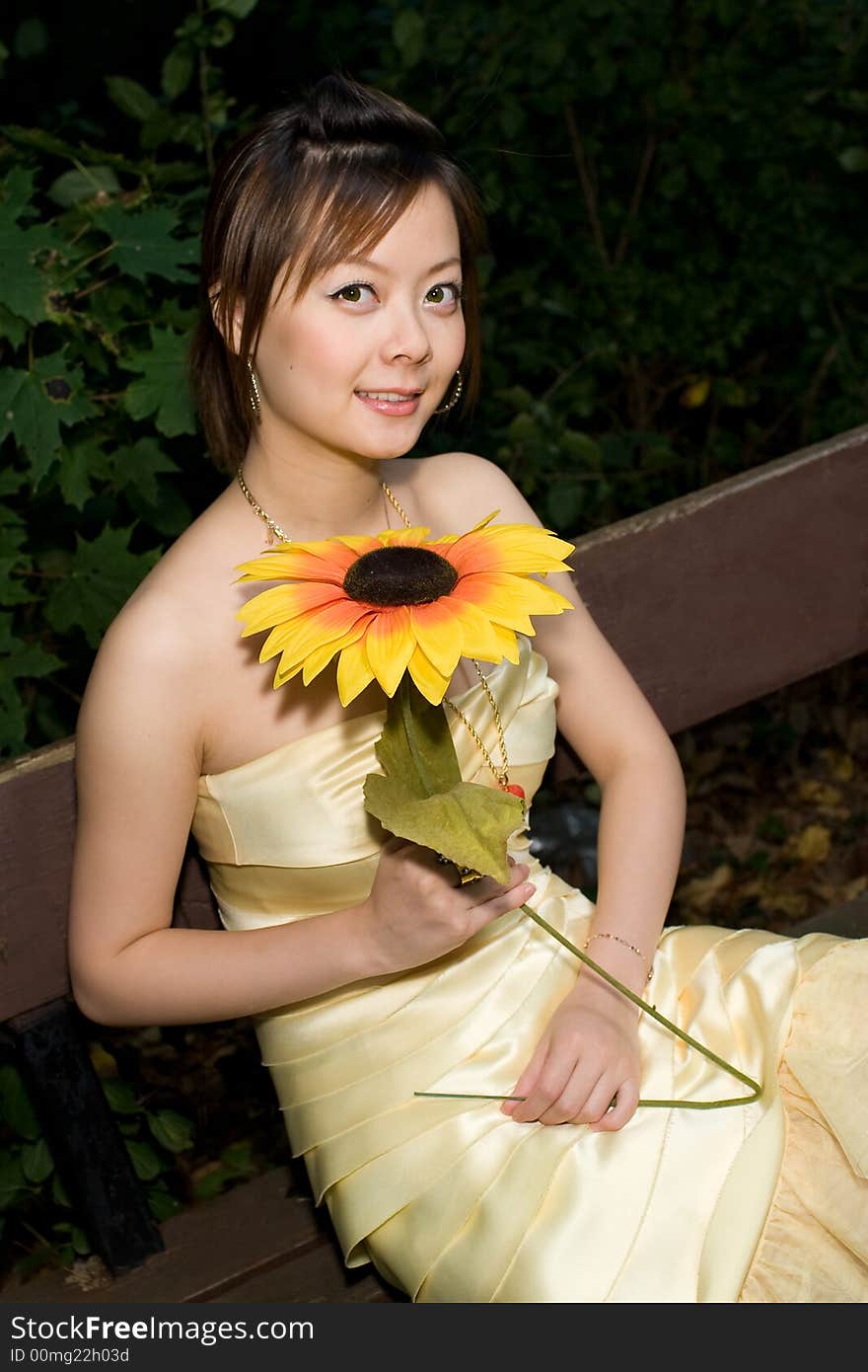 A girl holding a sunflower in woods. A girl holding a sunflower in woods