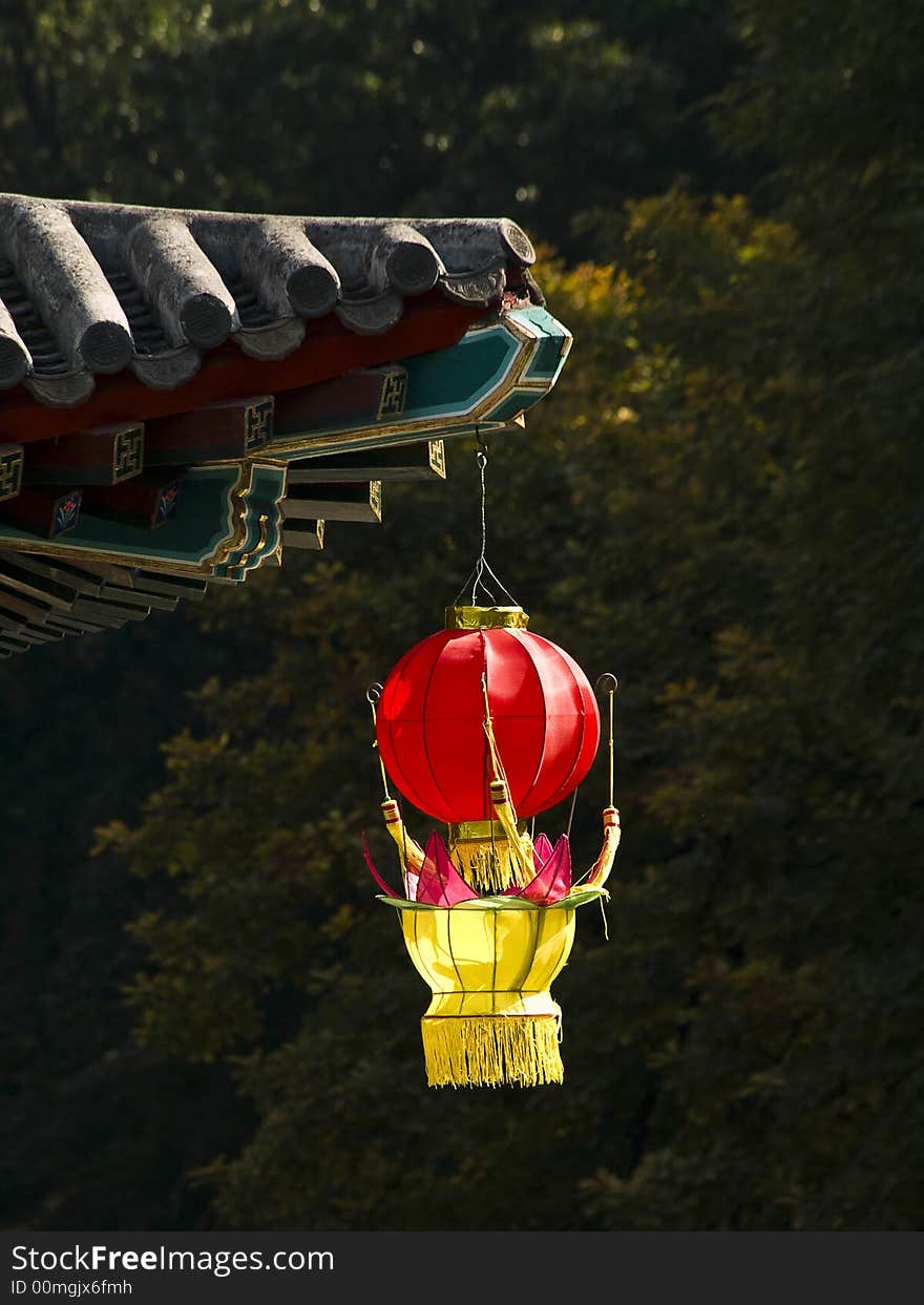Red and yellow lantern hanging at the edge of a chinese temple roof. Red and yellow lantern hanging at the edge of a chinese temple roof