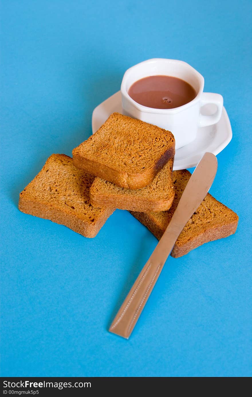 Slices of bread, coffee and coffee cup and knife, arranged on a blue background. Slices of bread, coffee and coffee cup and knife, arranged on a blue background