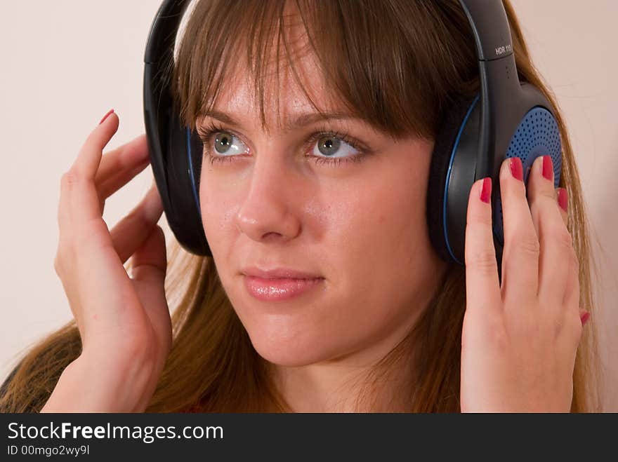 A girl, wearing headphones, listening to some music. A girl, wearing headphones, listening to some music