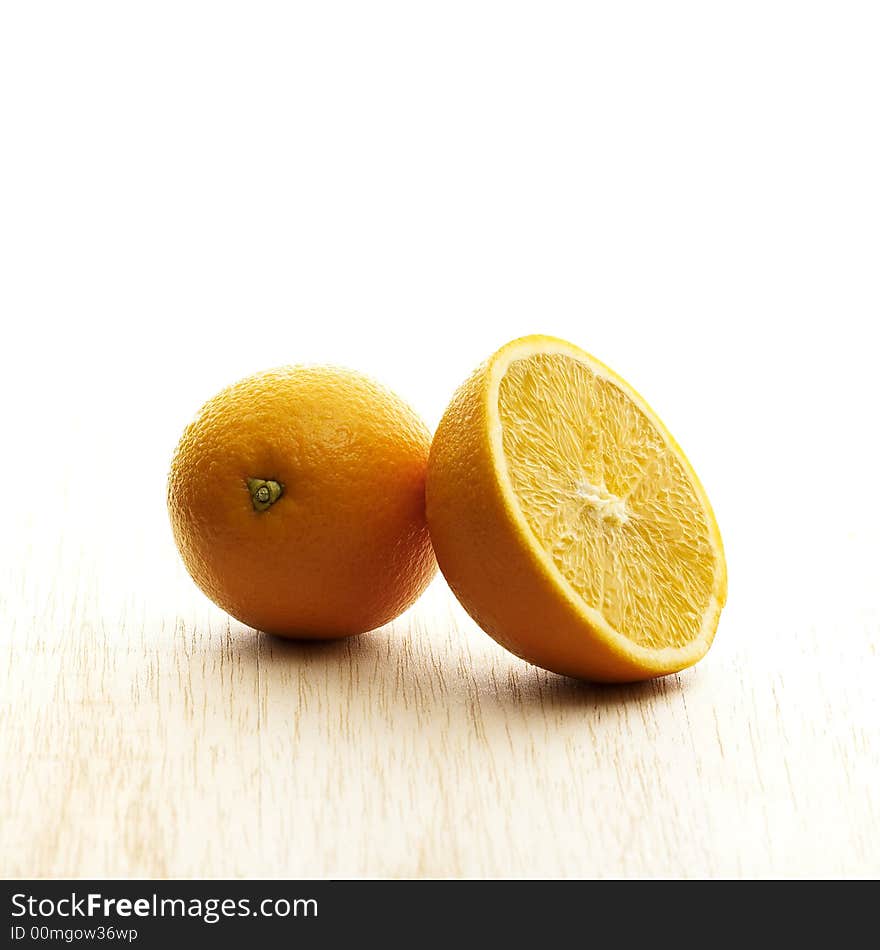 Whole and half orange on wooden board