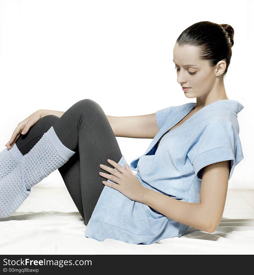 Side face of a young woman in bath robe sitting on bed. Side face of a young woman in bath robe sitting on bed