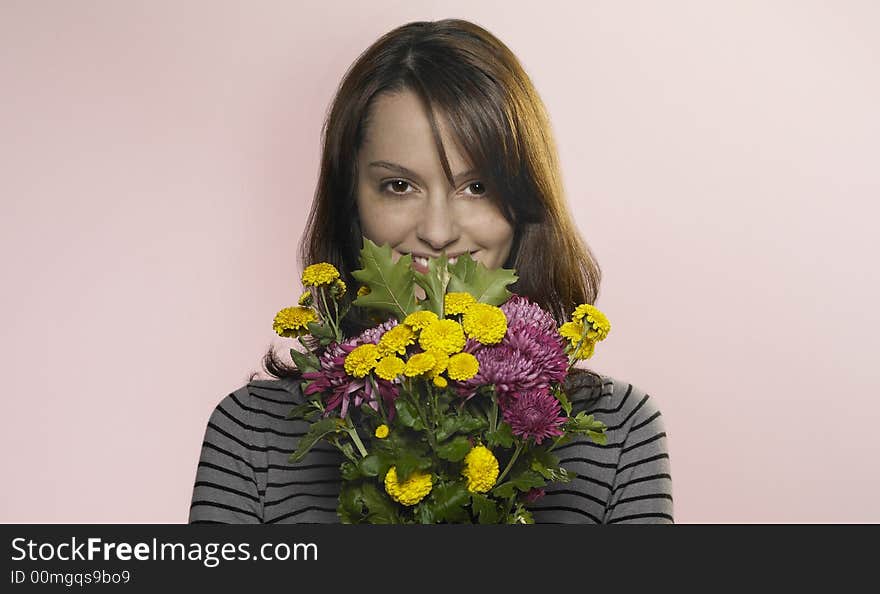 Woman smiling through a bunch of flowers. Woman smiling through a bunch of flowers