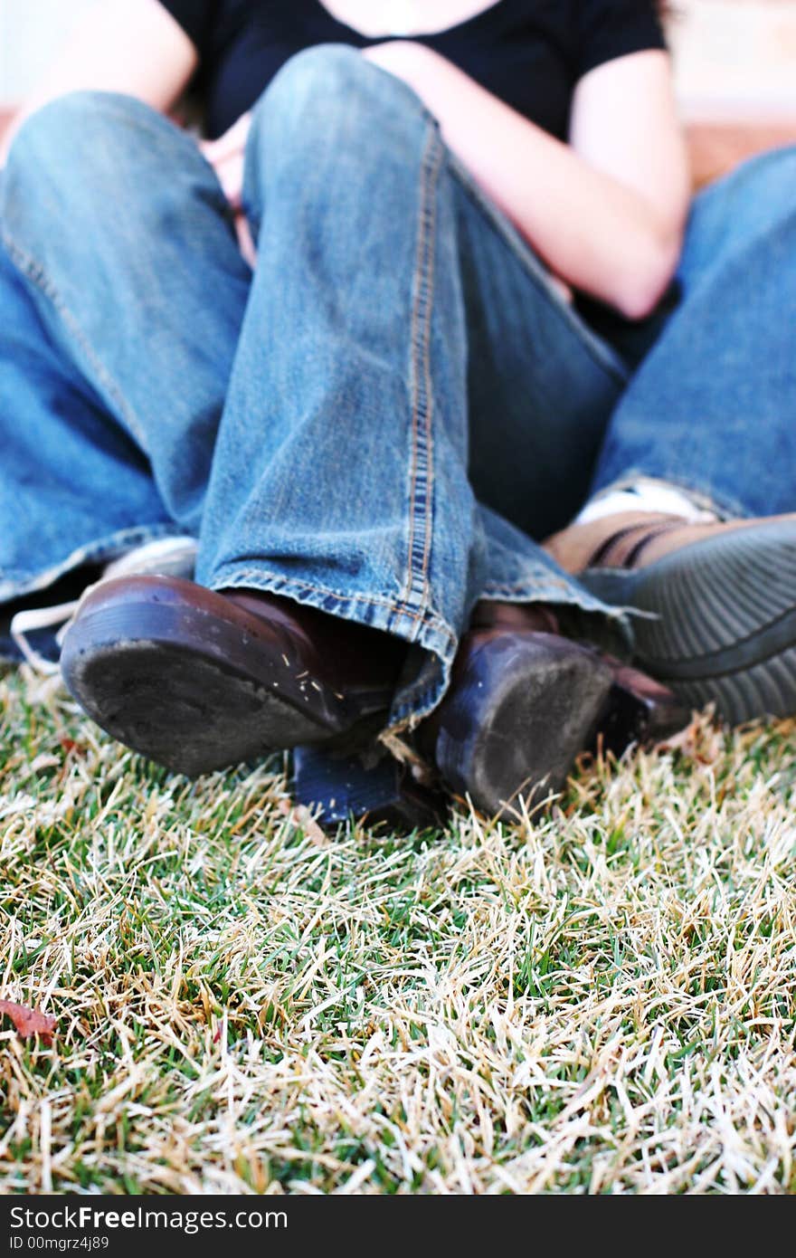 Three quarter length shot of heterosexual couple sitting down on grass together