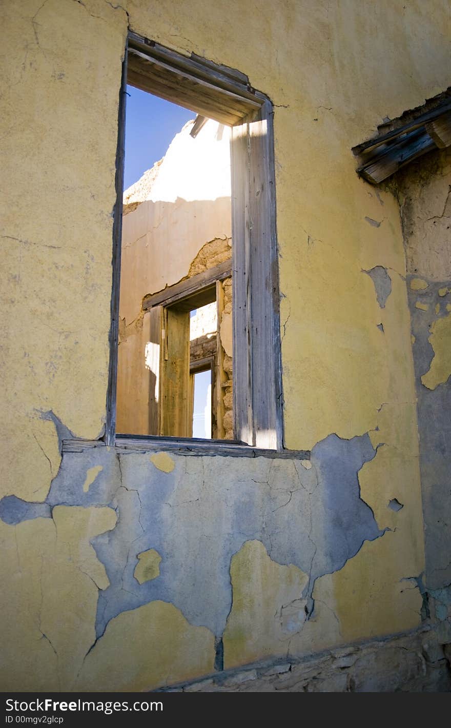 View through the window of an old abanoned building to a window and door of another room. View through the window of an old abanoned building to a window and door of another room.