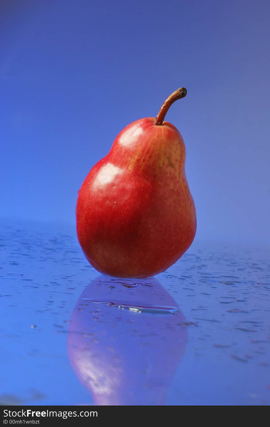 Red pear over blue background