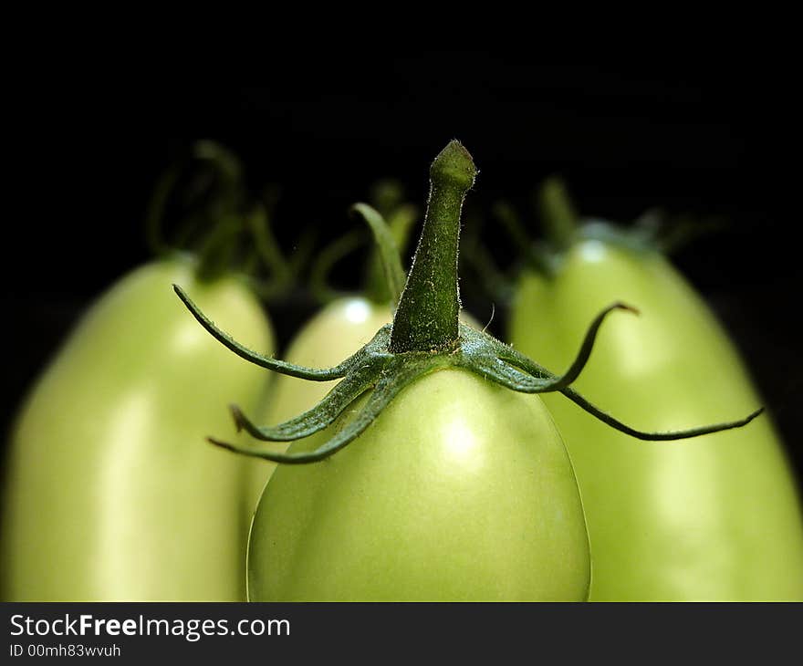 Group of thre green tomatoes close up on black background. Group of thre green tomatoes close up on black background