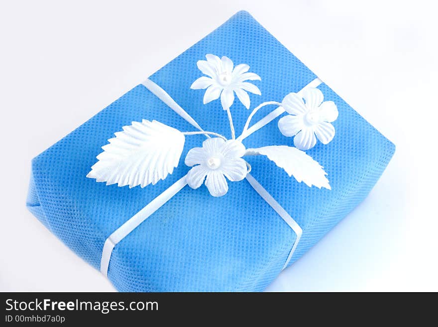 Lightblue gift box with white ribbon isolated on white