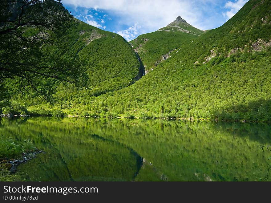 Lush green mountain reflecting in a lake. Lush green mountain reflecting in a lake