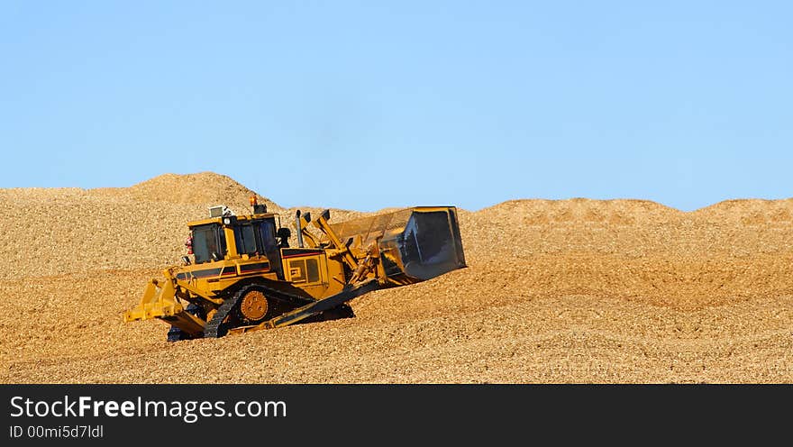 Large earthmover driving in wood chips. Large earthmover driving in wood chips