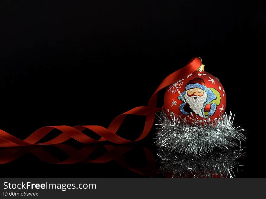 Red christmas tree ball with santa and red ribbon with reflection. Place for text