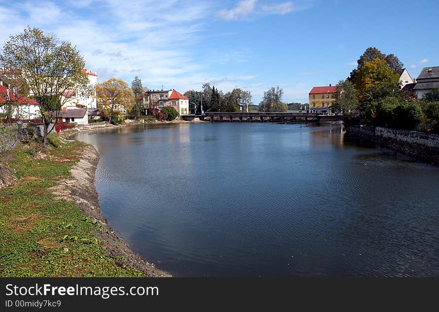 A river with several houses on a bank. A river with several houses on a bank