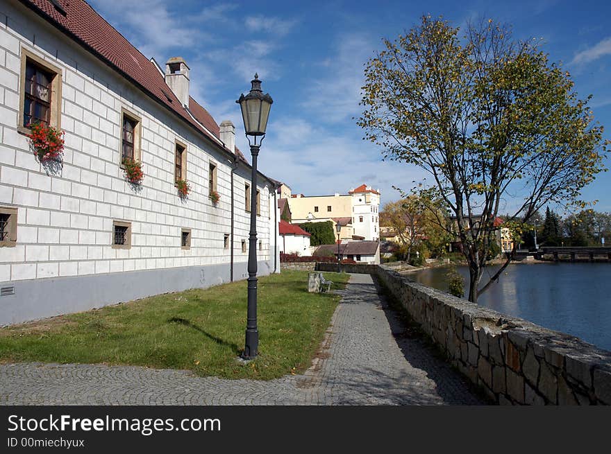 A river with several old houses  and a lantern on a bank. A river with several old houses  and a lantern on a bank