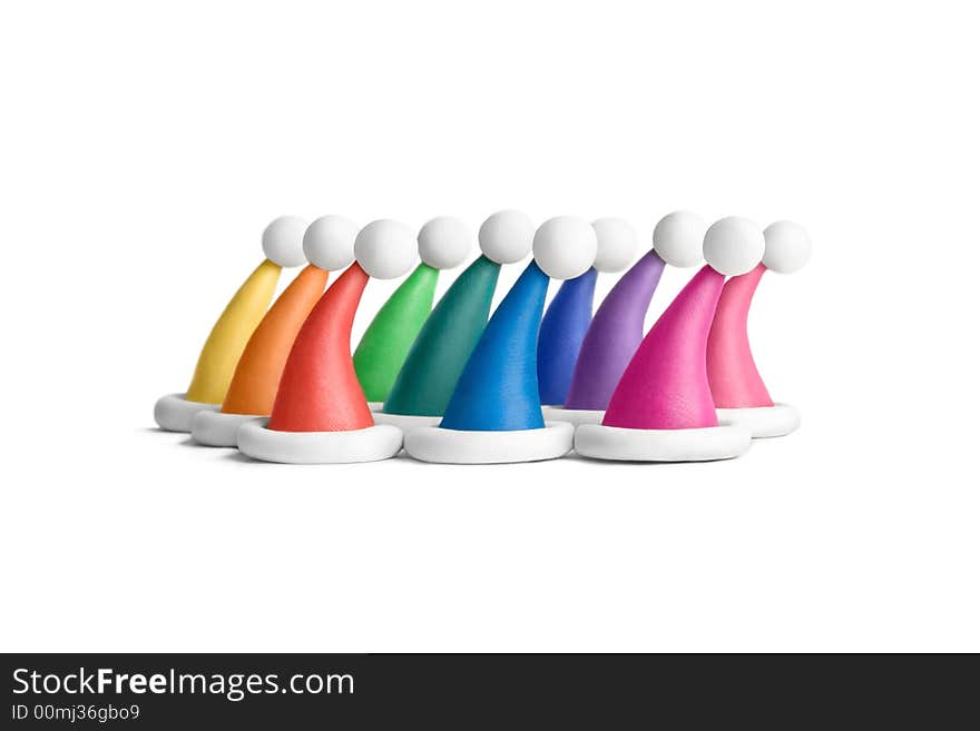 Multicolored plasticine Santa hats on a white background. Multicolored plasticine Santa hats on a white background