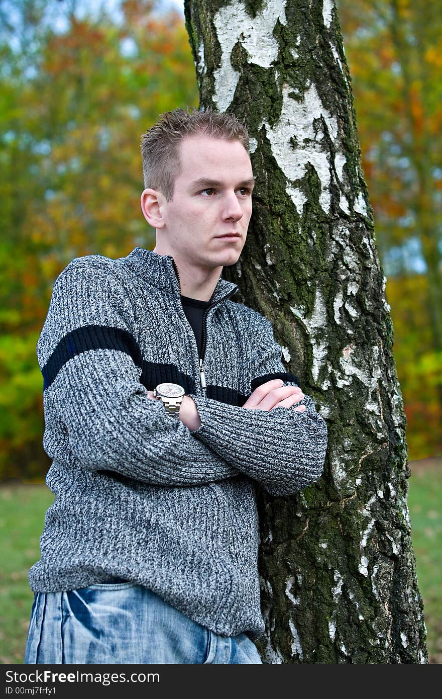 Boy is waiting befront of a tree. Boy is waiting befront of a tree