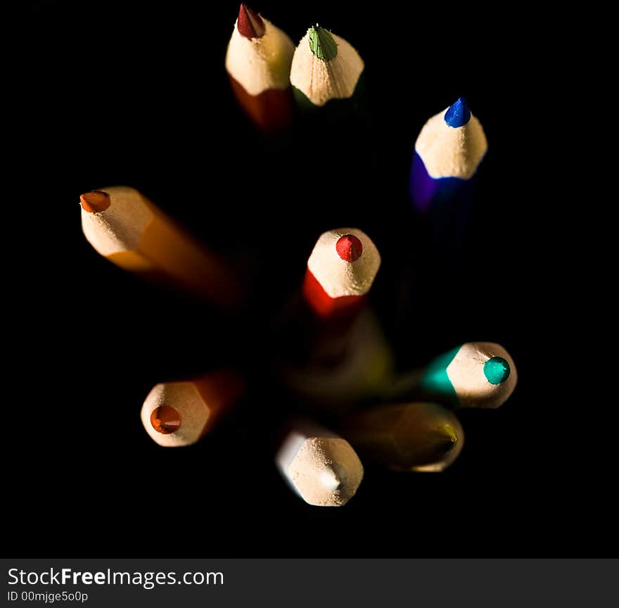 Thick colored pencils against a black background color