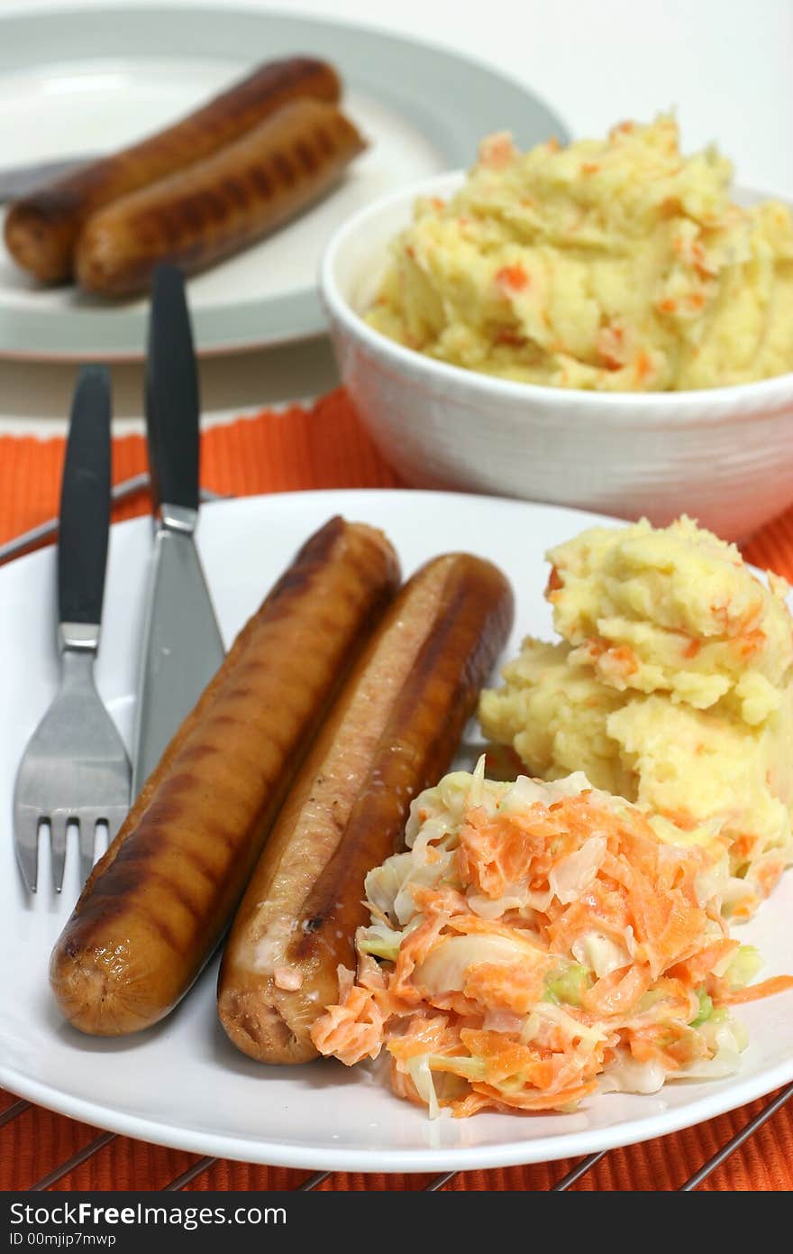 Large frankfurters with carrot and cabbage coleslaw and mash for dinner. Large frankfurters with carrot and cabbage coleslaw and mash for dinner