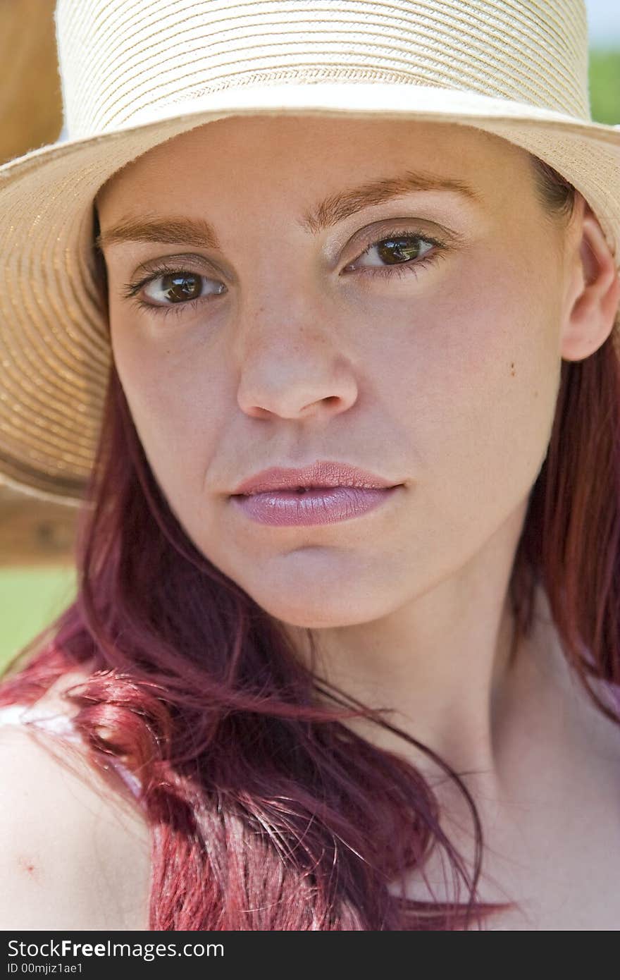 Closeup of the face of a beautiful young woman wearing a spring or summer hat. Closeup of the face of a beautiful young woman wearing a spring or summer hat.