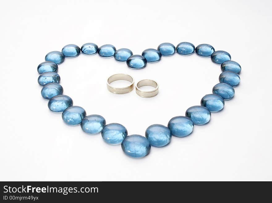 Wedding rings and blue pebbles