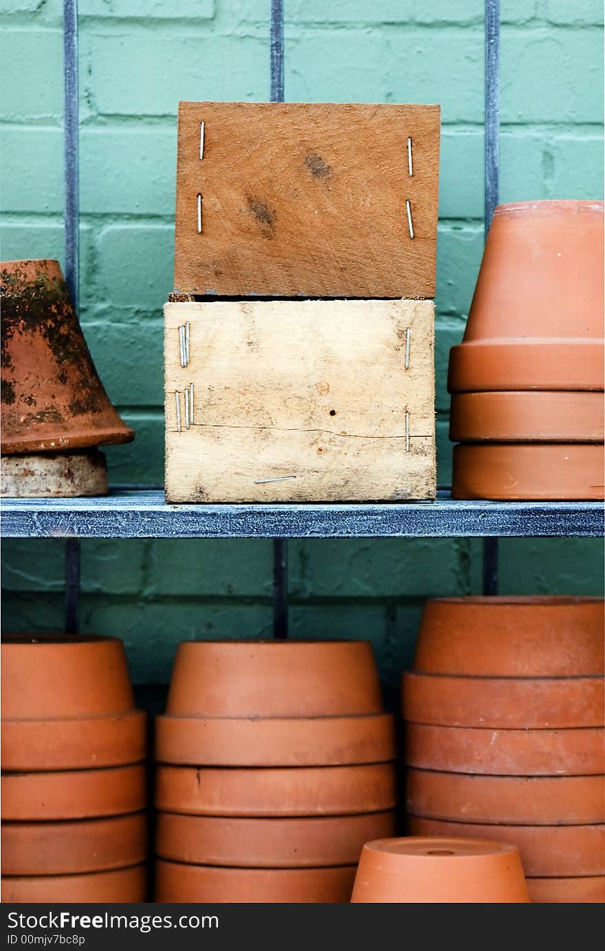 Two wooden boxes with space for advertisement surrounded with brown pots. Two wooden boxes with space for advertisement surrounded with brown pots