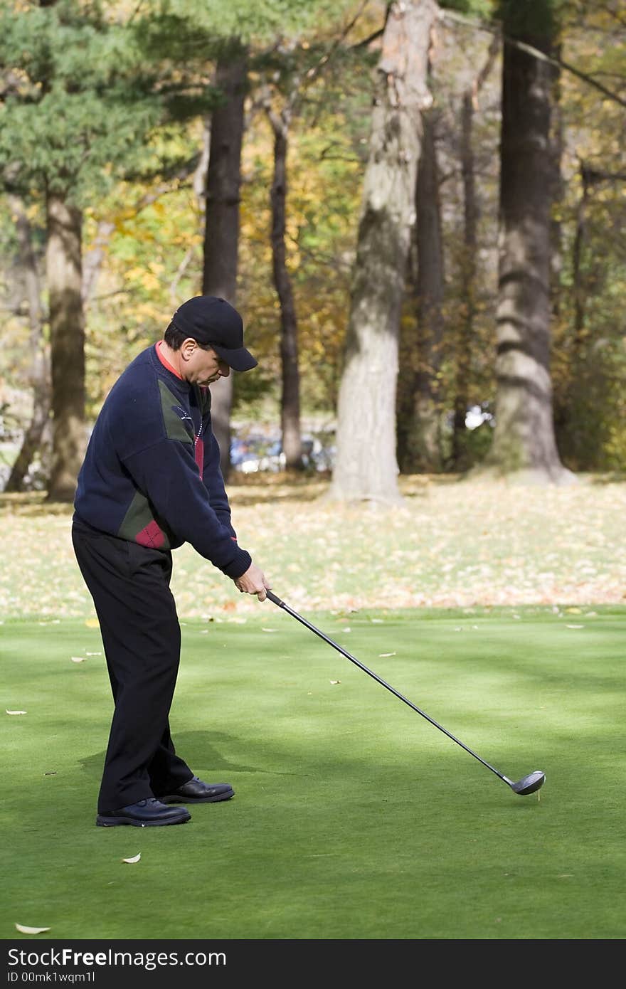 A male golfer plays a game on a beautiful fall day. A male golfer plays a game on a beautiful fall day.