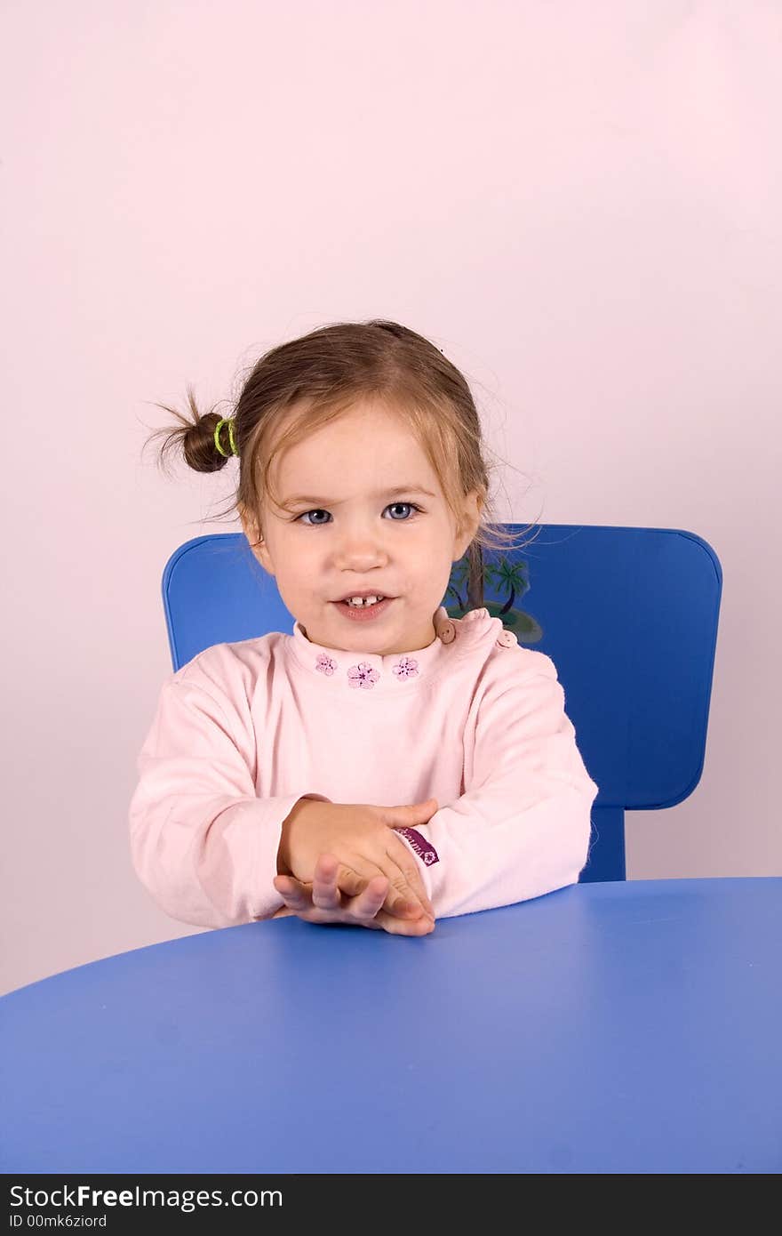 Little girl sitting on the chair and  playing