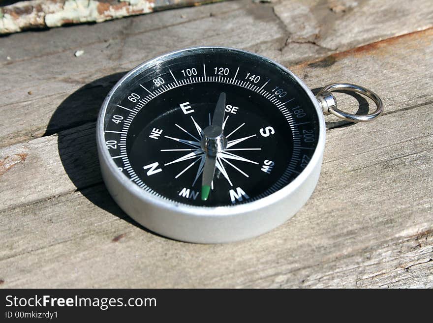 Compass on wood structure, in autumn light