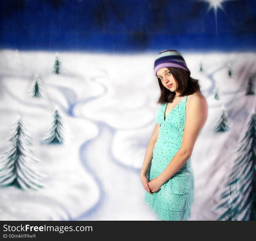 A girl standing against a snowy scenic background. A girl standing against a snowy scenic background.