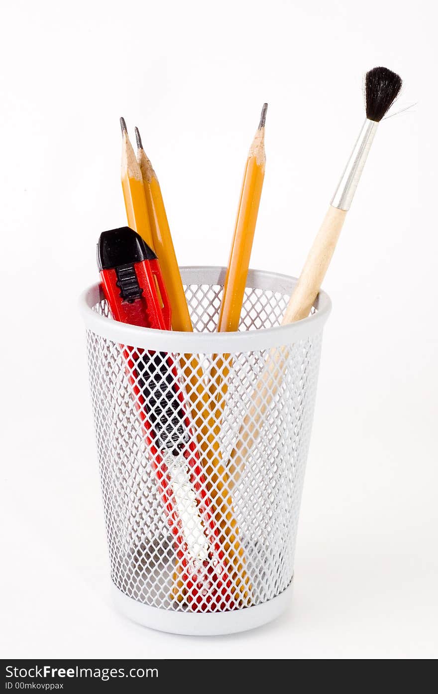 Pencil, paper knife and brush in basket holder