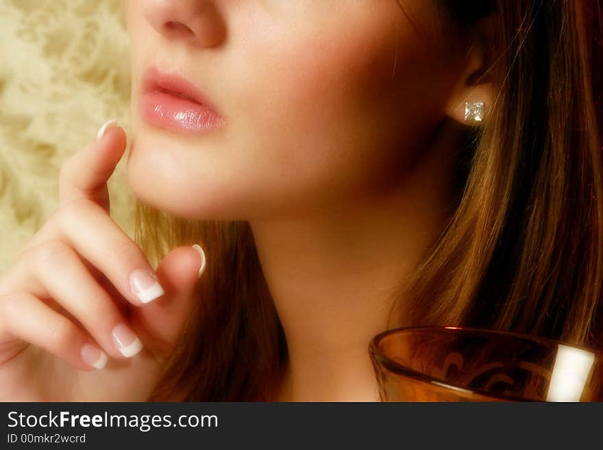 Close up of woman's lips and manicured hand. Close up of woman's lips and manicured hand.