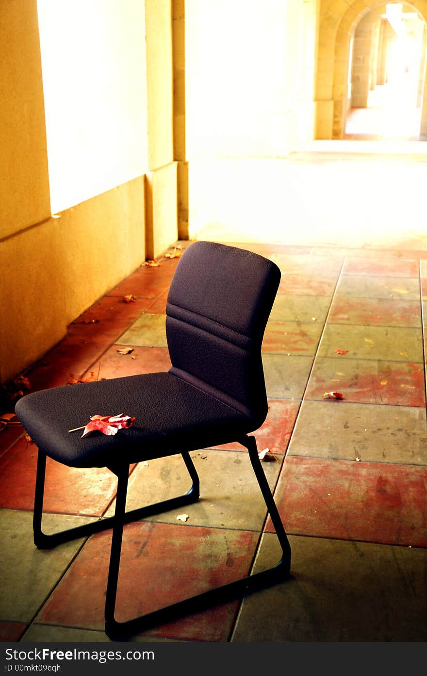 A lonely chair sitting in the hall way