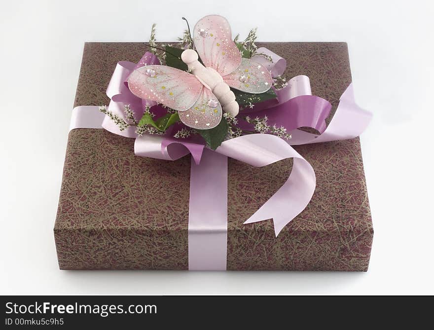 Many-coloured gift box with pink ribbon and butterfly isolated on white